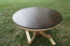 a wooden table sitting on top of a lush green field