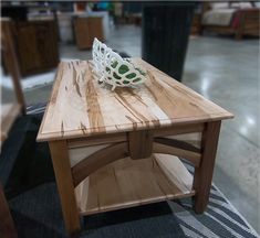 a wooden table with a bowl on top of it in a room filled with furniture