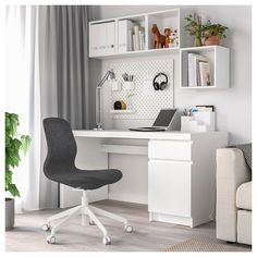 a white desk with a laptop computer on it next to a chair and bookshelf