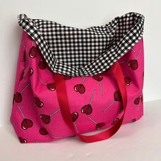 a pink bag with cherries on it