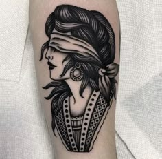 a black and white tattoo with a woman's face on her arm, wearing a headband