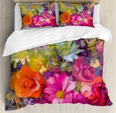 an image of a bed with colorful flowers on it and white sheets in the background