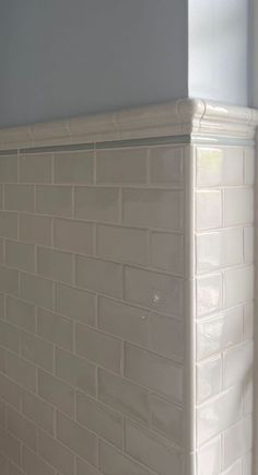 the corner of a white brick wall in a bathroom