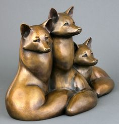 three bronze figurines sitting next to each other