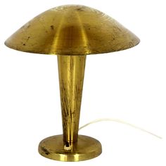 a gold colored table lamp on a white background