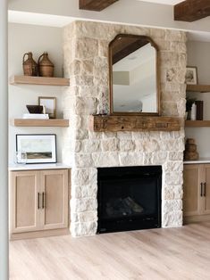 a living room with a fire place and wooden shelves on the wall, along with a large mirror above it