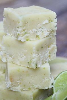 three pieces of cake sitting on top of a plate next to limes and a slice of lime