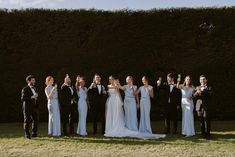 a group of people standing next to each other on top of a grass covered field