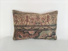 a decorative pillow with an intricate design on the front and back, sitting on a white surface