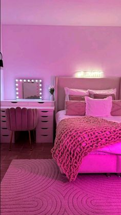 a bedroom with pink furniture and lights on the walls, along with a large bed