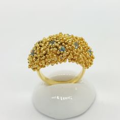 Gold Blue Topaz Ring. Embrace the allure of elegant design with our Handcrafted 24K Gold Vermeil Ring, studded with a captivating Natural Blue Topaz and embellished with granule detailing. A perfect blend of classic artistry and modern style, this piece is sure to add a touch of luxury to any ensemble. Features: Material: 925 Sterling Silver, 24K Gold Vermeil Sterling Silver  Stone: 10 pieces, 2mm  Natural Swiss Blue Topaz. Detailing: Hand-applied granules. Handcrafted: Each ring is uniquely cra Gold Aquamarine Jewelry With Accent Stones, Gold Crystal Ring With Stones For Anniversary, Anniversary Gold Crystal Ring With Stones, Gold Topaz Ring Fine Jewelry, Gold Topaz Ring In Fine Jewelry Style, Gold Topaz Crystal Ring, Gold Fusion Rings With Stones, Luxury Gold Aquamarine Rings, Gold Sapphire Crystal Ring