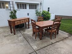 a wooden table and chairs in front of a garage