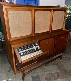 an old fashioned radio sitting on top of a wooden cabinet