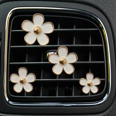 four flower shaped knobs on the front of a car's air conditioner