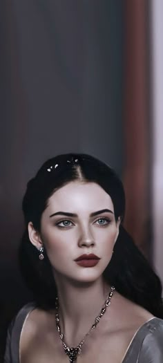 a woman with long dark hair wearing a silver dress and diamond necklace on her neck