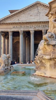 a fountain in front of a building with columns