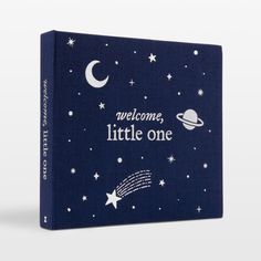 a blue book with the words welcome, little one written in white stars and planets