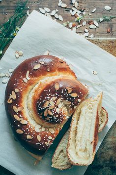 a loaf of bread with sesame seeds on top and sliced in half next to it