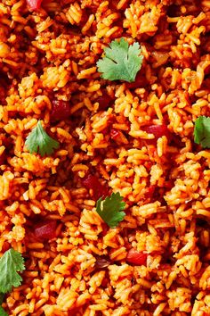 an overhead view of rice and vegetables with cilantro leaves on top, as well as garnishes