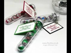 three christmas candy tubes with tags on them and some other items in the back ground