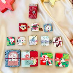 many small pieces of paper are laid out on a bed with white sheets and christmas decorations