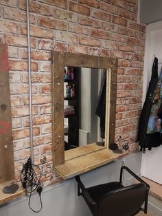 a room with a brick wall, mirror and chair in the corner next to it