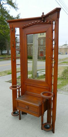 an antique wooden dressing table and mirror on the sidewalk in front of a street corner