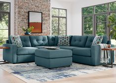 a living room with a blue sectional couch and ottoman