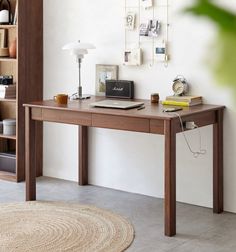 a desk with a laptop on it in front of a book shelf and bookshelf