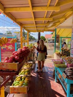 a woman standing in front of a fruit stand