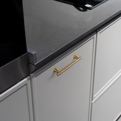 an image of a kitchen counter top that is painted gray and gold with brass handles