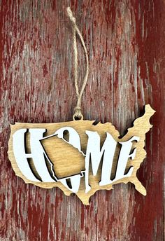 a wooden ornament with the word home hanging from it's side on a red door