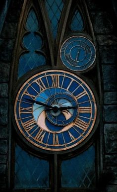 a large clock with roman numerals on the side of a church window,