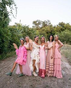 a group of women standing next to each other on a dirt road