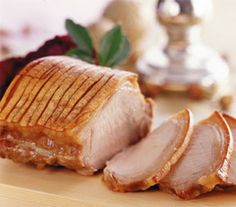 sliced meat sitting on top of a wooden cutting board