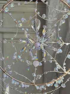 a chandelier with crystal beads hanging from it's centerpiece in front of a window