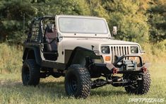 an old jeep is parked in the grass