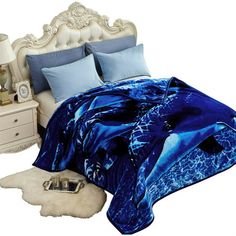 a bed with a blue comforter and pillows on top of it next to a night stand