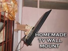 a tv wall mounted to the side of a pink building with text over it that reads homemade tv wall mount