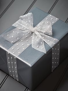 a blue gift box with white polka dots and a bow