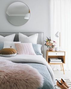 a bedroom with white walls and pink fur on the bed