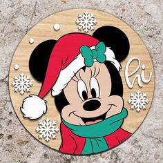 a mickey mouse christmas ornament with snowflakes on the background and an image of a person wearing a santa hat