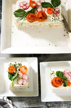 two plates with carrots, radishes and other food items on top of them