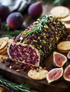 a wooden cutting board topped with sliced figs and crackers