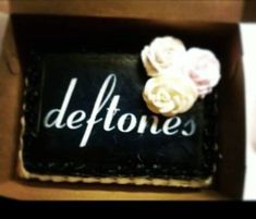 there is a black box with white flowers in it that says deftones on the side