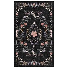 a black area rug with flowers and birds on the border, in front of a white background