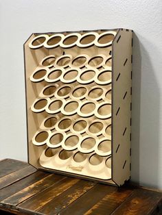 a cardboard box with circles on it sitting on top of a wooden table next to a white wall