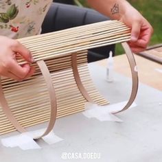 a person is holding a piece of wood and wrapping it around the edge of a table