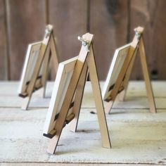 three small wooden easels sitting on top of a table