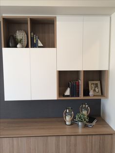 a book shelf with some books on it and two vases in front of it